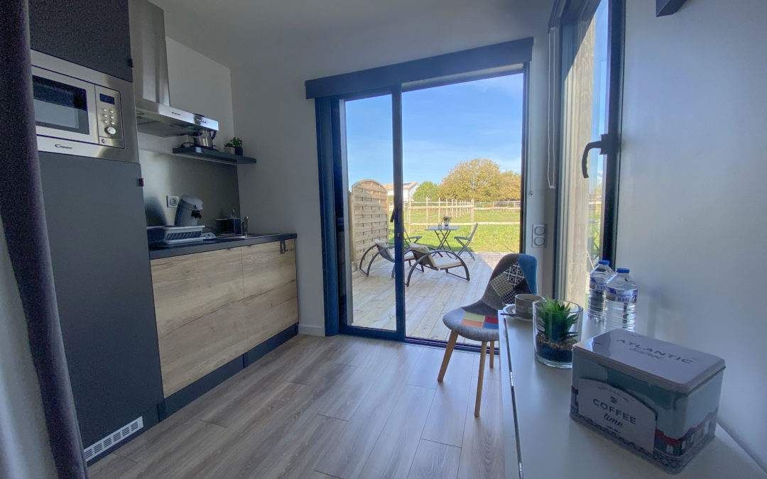 intérieur d'un studio de jardin vue cuisine et terrasse